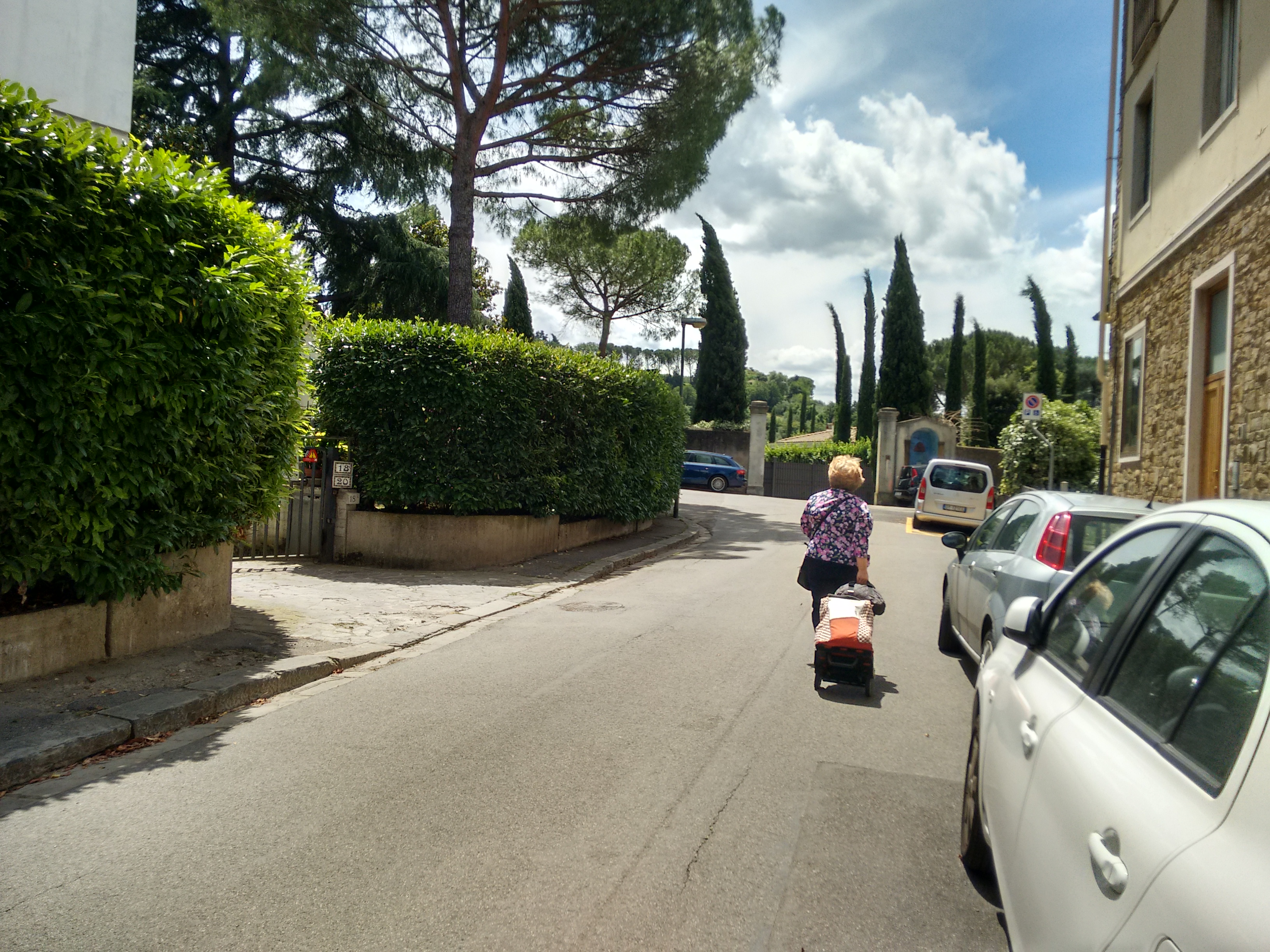 Un'anziana che percorre via di San Vito sole con la spesa