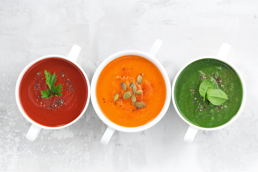 assortment of colorful vegetable cream soup on a white background, horizontal