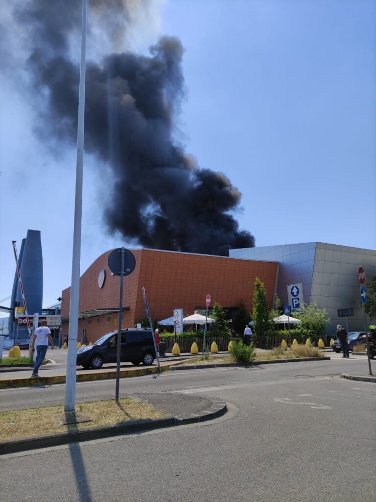 Una densa colonna di fumo nero e fiamme si sprigionarono dal centro commerciale