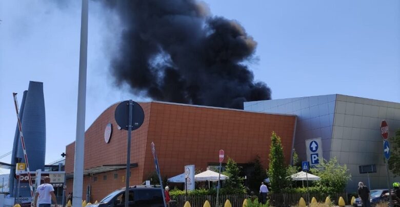 Una densa colonna di fumo nero e fiamme si sprigionarono dal centro commerciale